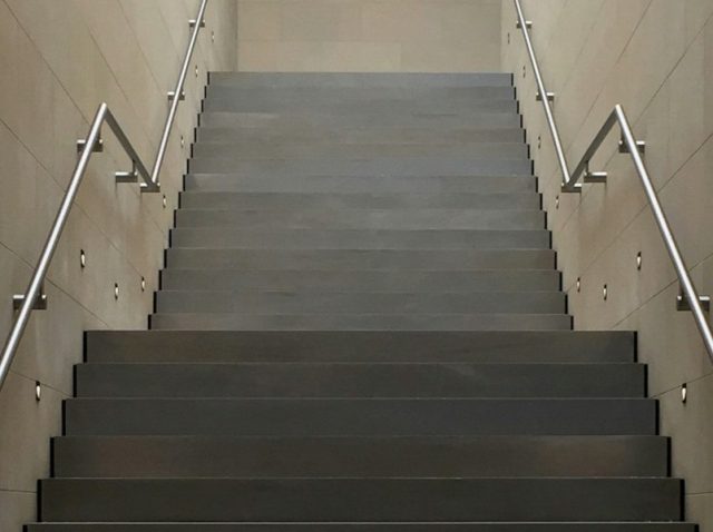Escadaria minimalista com corrimãos, simbolizando etapas do funil e a evolução no CRM completo da equipe comercial.
