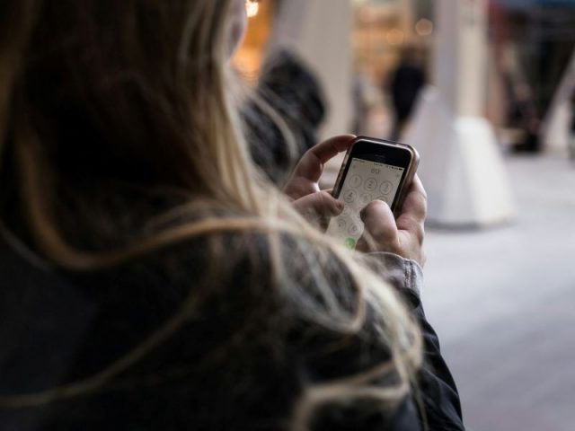 Profissional usando smartphone para gerenciar tarefas de vendas em movimento, representando o uso de CRM móvel no dia a dia comercial.