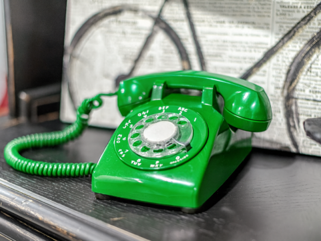 Imagem de um telefone antigo e na cor verde que remete à ideia do artigo, que fala sobre prospecção ativa no WhatsApp