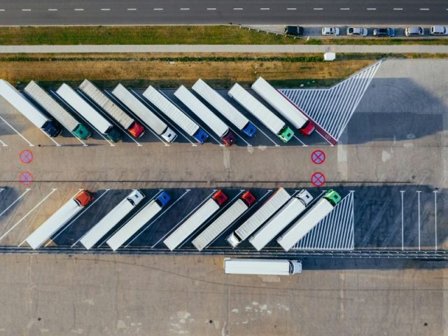 Pátio com caminhões estacionados visto de cima, ilustrando a operação de vendas nas distribuidoras
