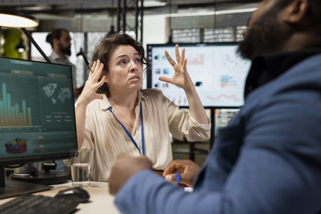 Mulher de negócios sob pressão, frustrada com um colega de trabalho